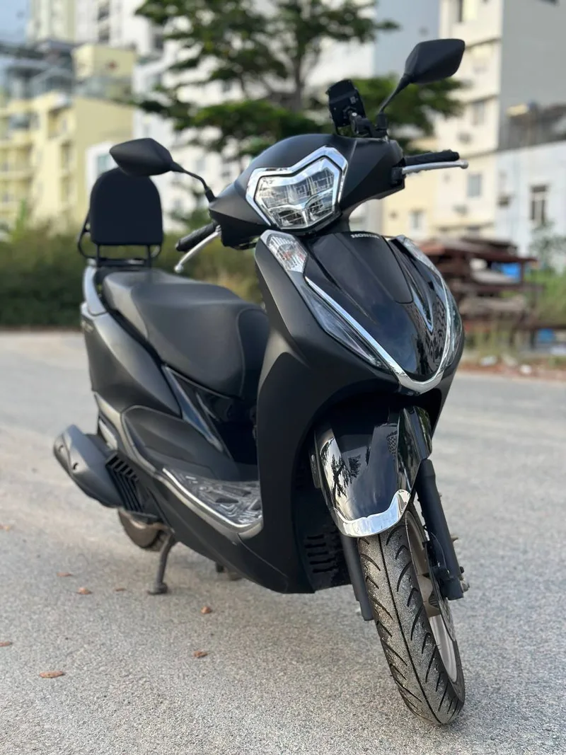 Чёрный скутер Honda на улице в мягком вечернем свете