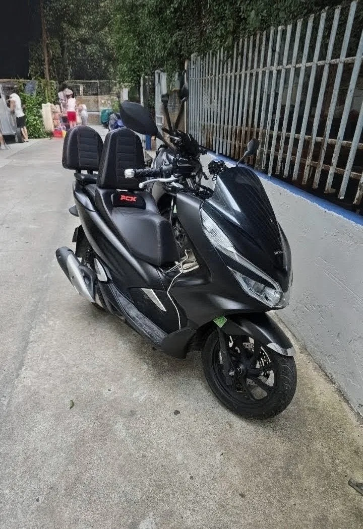 Чёрный Honda PCX 150 у белого забора